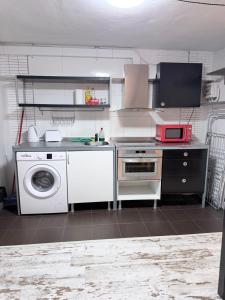 a kitchen with a stove and a washing machine at Blue rooms in Bilbao