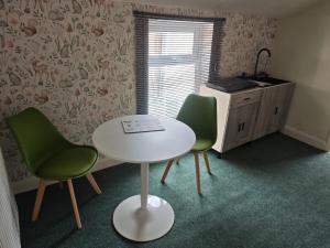 a room with a table and two chairs and a kitchen at St Peters Avenue in Cleethorpes