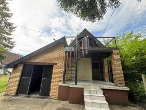 a brick house with a staircase on top of it at Vikendica in Bezdan