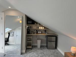 a kitchen with a sink and a counter under a staircase at Coastal Skylight Studio in Bettystown