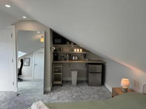 a room with a kitchen and a staircase with a counter at Coastal Skylight Studio in Bettystown
