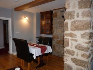 a dining room with a table and a stone wall at The Old Seven Stars in Okehampton
