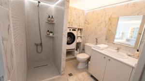 a bathroom with a shower and a toilet and a sink at Laskas Apartment in Stalís