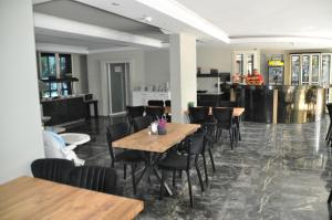 a restaurant with wooden tables and chairs and a kitchen at Citrus Urban Hotel in Antalya