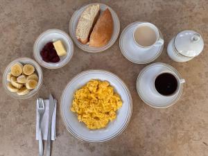 a table with plates of breakfast foods and a cup of coffee at Hotel Amazonas Real in Leticia