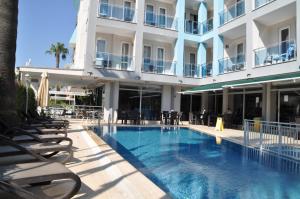 a hotel swimming pool with lounge chairs and a building at Citrus Urban Hotel in Antalya