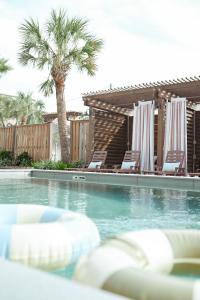 a swimming pool with lounge chairs and a palm tree at The Mansard House in Galveston