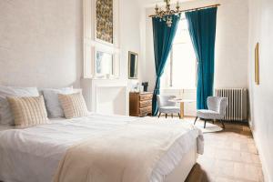 a bedroom with a white bed and a table and chairs at Maison Pistache in Le Dorat
