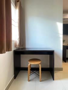 a black desk with a wooden stool next to a window at U Dee Room and Coffee in Kanchanaburi City +65 photos