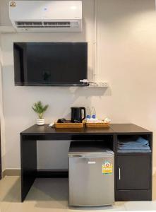 a kitchen with a black counter with a microwave and a table at U Dee Room and Coffee in Kanchanaburi City