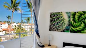 a room with a window with a picture of a palm tree at Hotel Garden Flora Punta Cana Beach in Punta Cana
