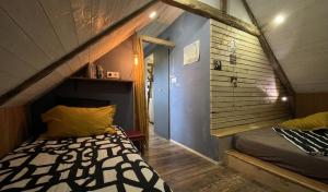 a small room with a bed in a attic at Le Loft de l'auberge du Lac Noir in Saint-Cernin-de-Larche