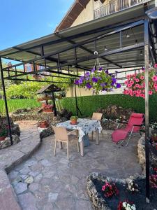 a patio with a table and chairs under a pergola at DrimResidence in Struga
