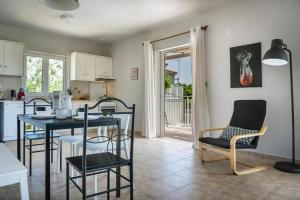 a kitchen and dining room with a table and chairs at Villas LaVista in Skala