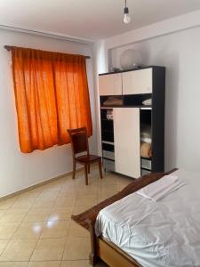 a bedroom with a bed and a chair and a window at Olive in Tirana