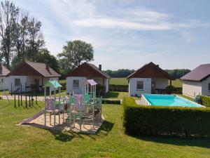 a yard with a playground and a swimming pool at Domki Pod Kasztanem in Dąbki