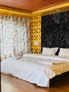 a bedroom with a white bed with a wall at Star Palace in Pahalgām