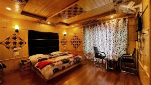 a bedroom with two beds and a desk in it at Star Palace in Pahalgām +5 photos