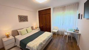 a bedroom with a bed and a desk and a table at Comfort Rooms Near Lisbon Airport - Carlotta Living in Lisbon