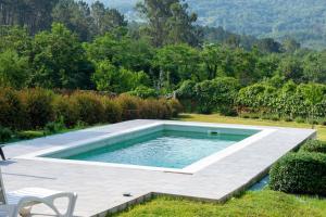 a swimming pool in the middle of a yard at o fogar do cipres in Rivela