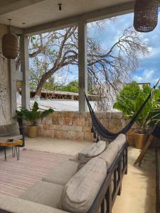 a hammock on a porch with a view of a tree at Hotel Makaabá Eco-Boutique in Bacalar
