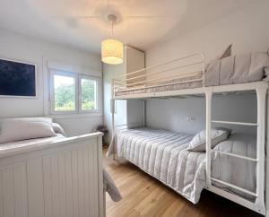 a bedroom with two bunk beds and a window at o fogar do cipres in Rivela +27 photos