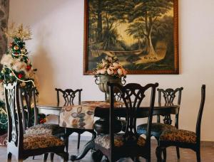 a dining room with a table and chairs and a painting at Hotel Boutique El Rosario in Teapa +23 photos