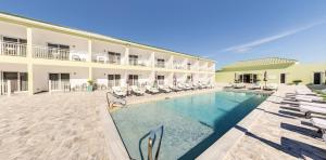 a hotel with a swimming pool and lounge chairs at Ocean Breeze Resort in NCA