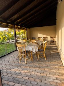 a patio with a table and chairs on a roof at Pensiunea Casa Deny in Novaci-Străini