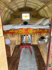 an inside view of a small room with a bed at Vardo gypsy wagon in Berwick Saint John