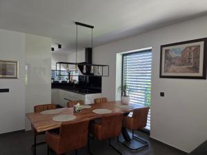 a dining room with a wooden table and chairs at Private House with Jacuzzi and Sauna in Domžale
