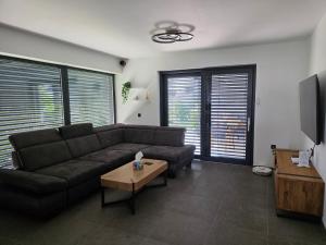a living room with a couch and a table at Private House with Jacuzzi and Sauna in Domžale