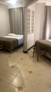 a room with two beds and a tiled floor at Suíte Master Particular Alto Padrão com Vaga e Estrutura de Hotel em Florianópolis in Florianópolis +8 photos