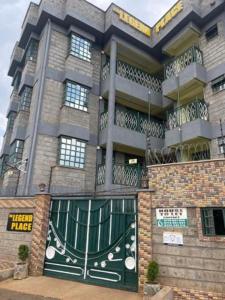a large building with a green door and balcony at The Legend Place in Eldoret