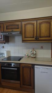 a kitchen with wooden cabinets and a stove top oven at Glencar in Sligo