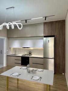 a kitchen with a white table and a refrigerator at Tamerlane Premium Apartment in Samarkand
