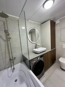 a bathroom with a tub and a sink and a toilet at Tamerlane Premium Apartment in Samarkand