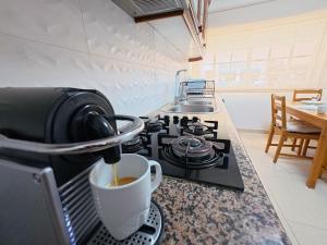 a cup of coffee on a stove in a kitchen at Comfort Rooms Near Lisbon Airport - Carlotta Living in Lisbon