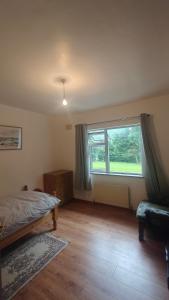 a bedroom with a bed and a large window at Glencar in Sligo