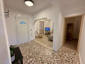 a hallway with a white door and a living room at Mosaic House in Sami
