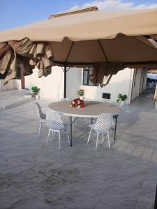 a table and chairs under an umbrella on a patio at The Bird House in Munyu