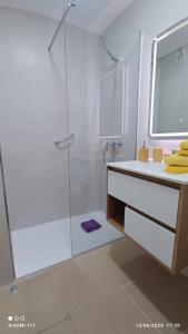 a white bathroom with a shower and a sink at The Apartment in Gran Tarajal +31 photos