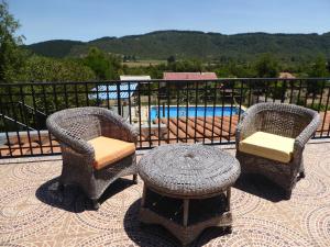 a patio with two chairs and a table and a pool at La Maravilla Lodge in Vilches