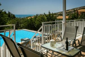 a patio with a table and chairs next to a pool at Villas LaVista in Skala