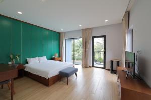a bedroom with a bed and a green wall at MT Luxury Villas Phu Quoc in Phú Quốc