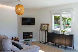 a living room with a couch and a window at o fogar do cipres in Rivela
