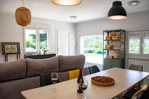 a living room with a couch and a table with wine glasses at o fogar do cipres in Rivela