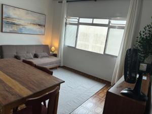 a living room with a couch and a table at Apartamento Brisa Do Mar em Peruíbe in Peruíbe