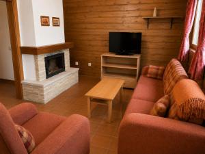 a living room with two couches and a fireplace at Drevenica Podkovička - Terchová in Terchová