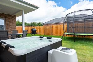 a hot tub in a yard with a swing at Sonne & Sand Strandnahes Ferienhaus mit Whirlpool, Sauna & Wallbox in Büsum